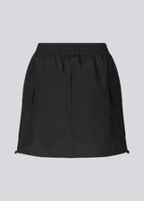 Short skirt in nylon with elastic waist and adjustable hems with elastic drawstrings. TrentMD skirt has two patch pockets and vertical cutlines on front and back.