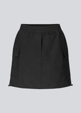 Short skirt in nylon with elastic waist and adjustable hems with elastic drawstrings. TrentMD skirt has two patch pockets and vertical cutlines on front and back.