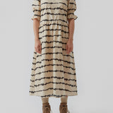 Midi kjole med korte pufærmer med elastik. Poem print dress har et batikfarvet print og er lavet i ansvarligt bomuld. Skørtet tilføjer masser af volumen og et feminint udtryk. Modellen er 173 cm og har en størrelse S/36 på