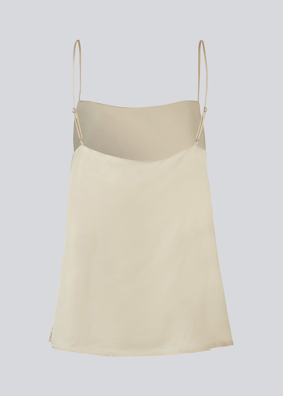 Satin top i beige med justerbare spaghetti-stropper og enkelt udtryk. CarwynMD top har A-facon og lige udskæring. Modellen er 177 cm og har en størrelse S/36 på.