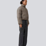 Slightly cropped brown puffer with a high neck. JoniMD jacket has side pockets, elastic at the sleeves and an adjustable string at the hem.