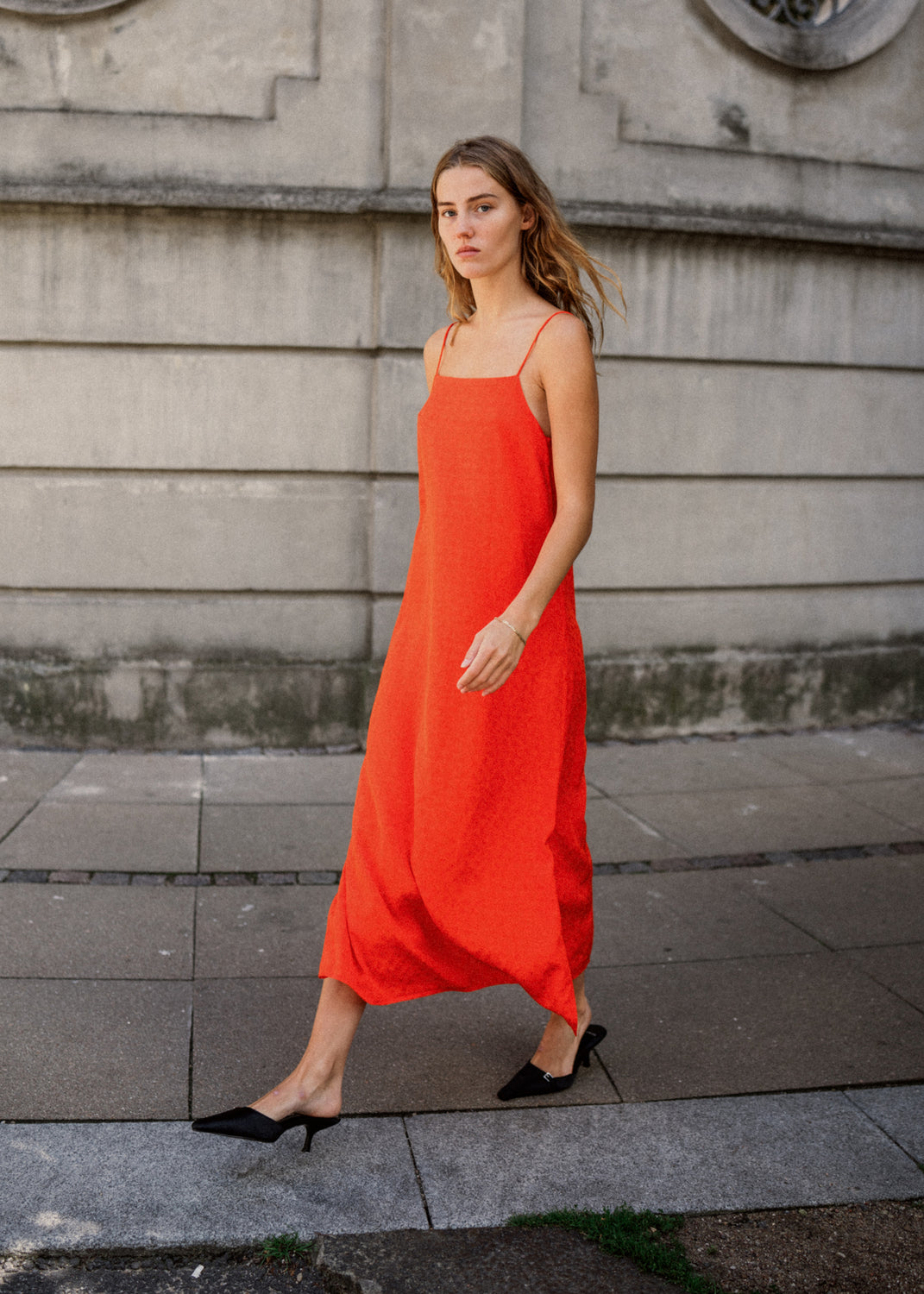 Long strap dress in bright cherry in satin with woven pattern and a loose silhouette. FallowMD dress is styled with thin straps. The dress is lined. The model is 175 cm and wears a size S/36.