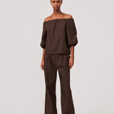 Suit pants in dark brown in a cotton blend with a relaxed silhouette and wide legs. DeenMD pants have a medium waist, zip fly, and pleats at the front. The model is 177 cm and wears a size S/36.