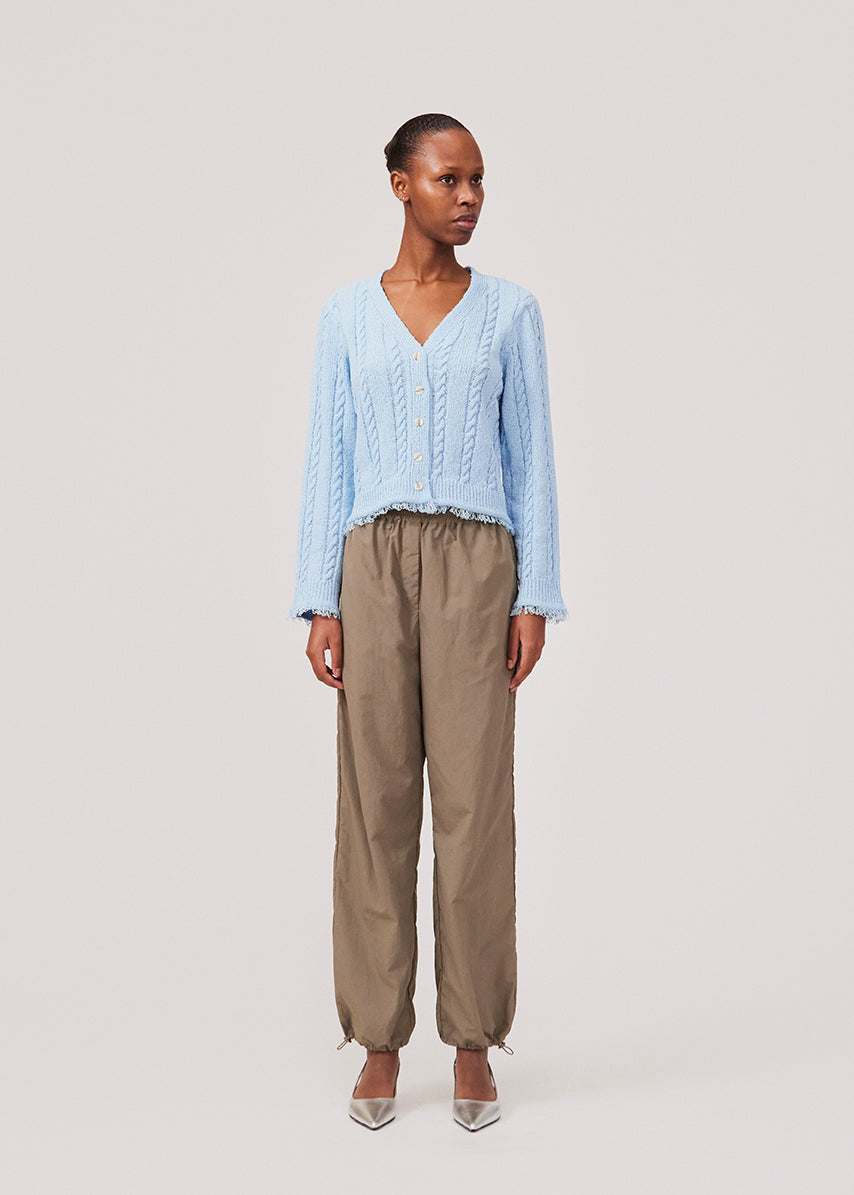 Parachute pants in beige in nylon with a relaxed fit. FumikoMD pants have a regular waist with elastic, wide legs and elastic drawstring at the waist. The model is 175 cm and wears a size S/36.