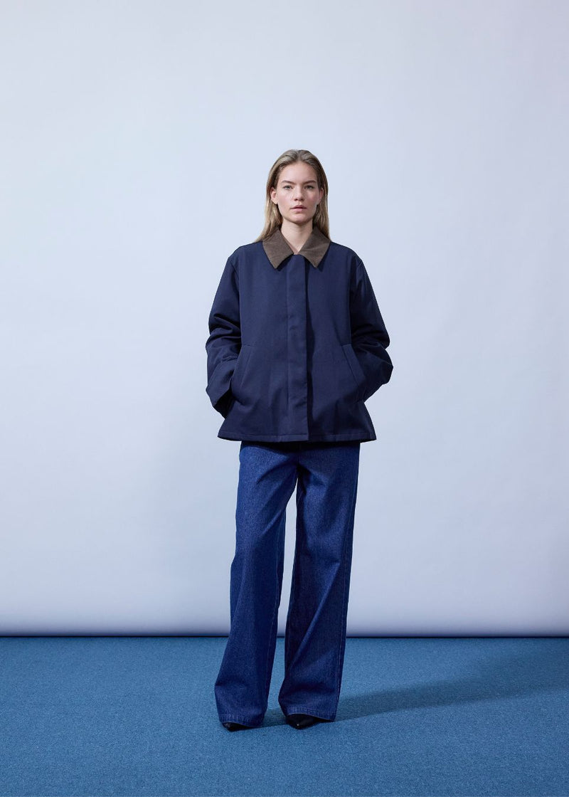 Lose jacket with corduroy collar and hidden press buttons. Orkidemd jacket has an inverted pleat on the back. The model is 175 cm and wears a size s/36.