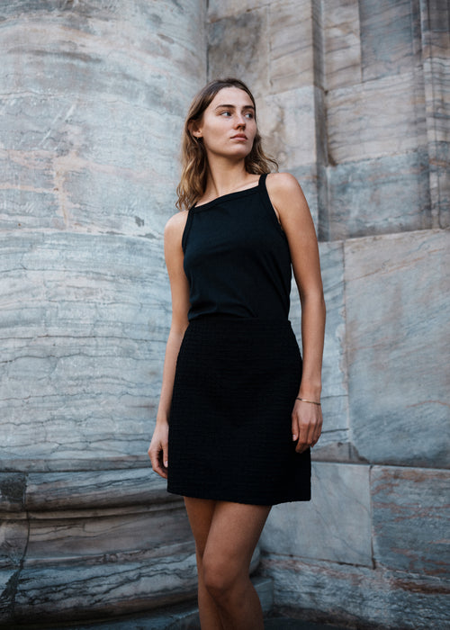 Tight fit basic black top with a high and straight neckline. DaeMD top is made from a rib-knitted organic cotton. The model is 177 cm and wears a size S/36.