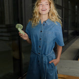 Short denim playsuit with a tieband in 100% organic cotton. NaomaMD solid playsuit has a button closure in front, a shirt collar, and side pockets.