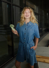 Short denim playsuit with a tieband in 100% organic cotton. NaomaMD solid playsuit has a button closure in front, a shirt collar, and side pockets.