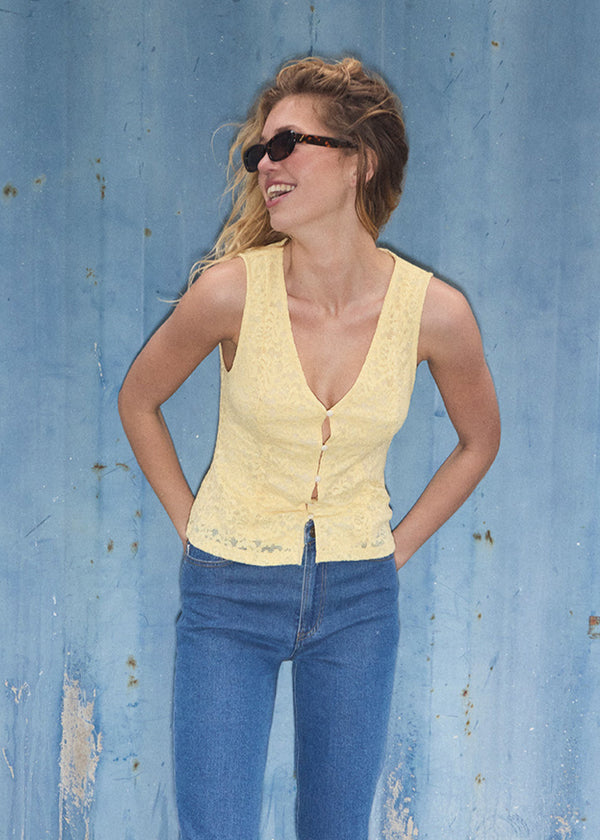 Sleeveless lace top in yellow with a v-neck. MamumdMD top is fitted and has a button closure in front.
