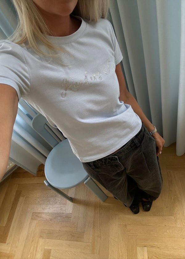 Fitted T-shirt with rhinestone print in organic cotton. Plaimamd print shirt is slightly cropped and has a round neck. The model is 175 cm and wears a size s/36.