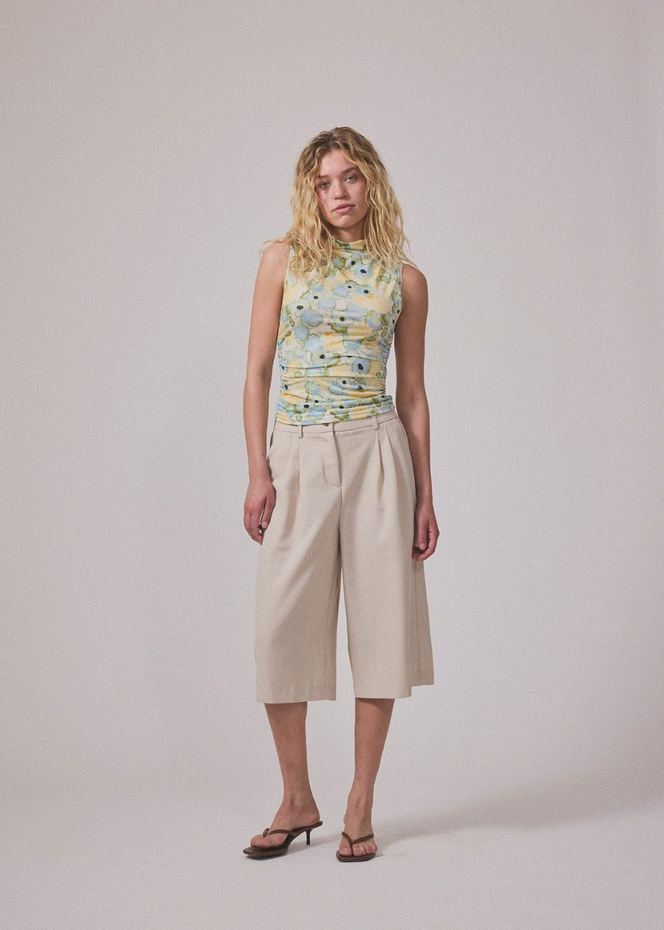 fitted top in an elastic material. NettieMD print top is sleeveless, has a high neckline, and has gatherings in the side