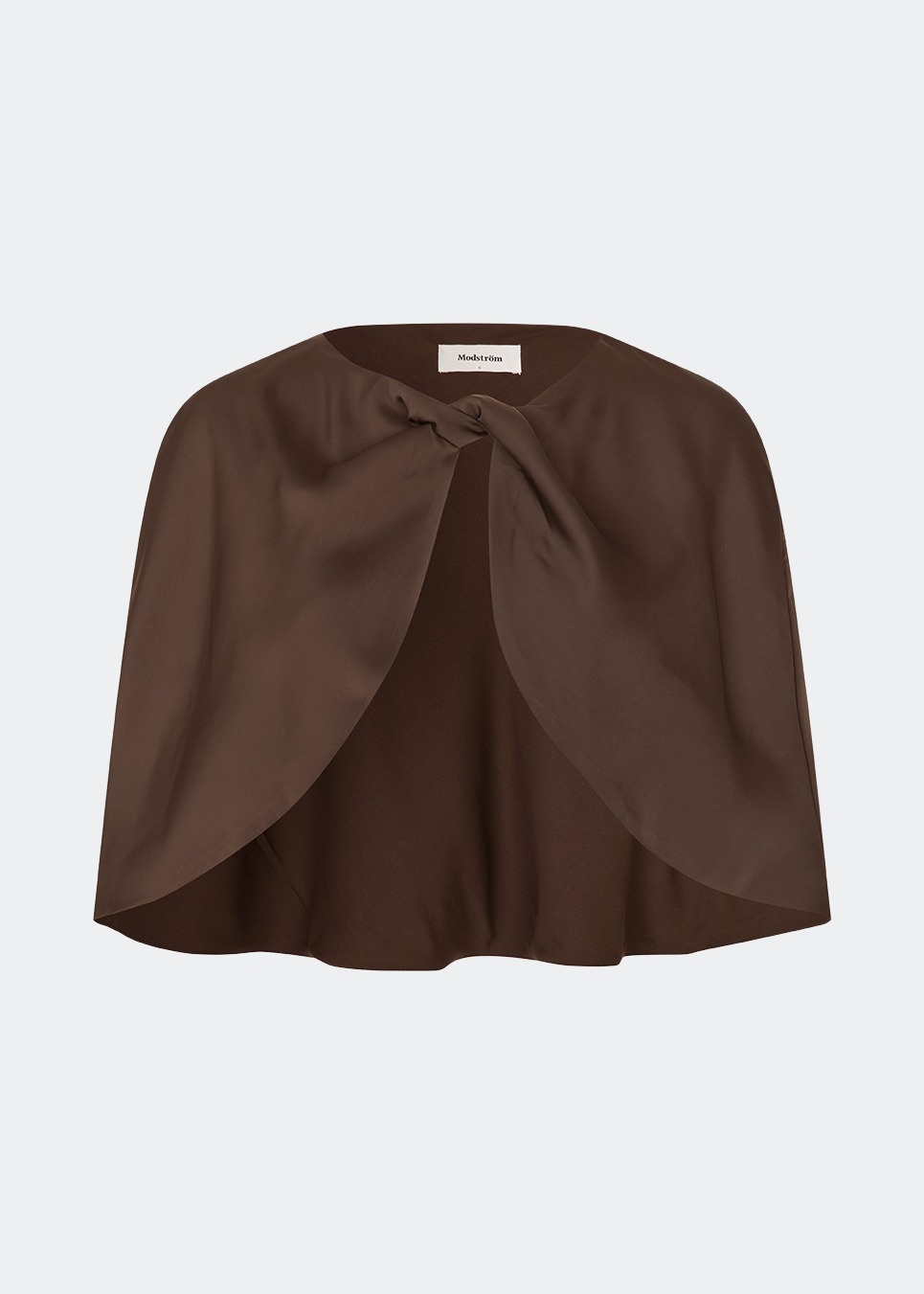 Tailormd Cape is an elegant satin cape designed to add a refined and dramatic finish to any outfit. It drapes effortlessly over the shoulders and fastens at the front with a decorative knot detail, creating a soft, fluid silhouette. Layer it over a dress for special occasions or style it with a simple top for an elevated, sophisticated look. The model is 175 cm tall and is wearing a size S/36.