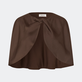 Tailormd Cape is an elegant satin cape designed to add a refined and dramatic finish to any outfit. It drapes effortlessly over the shoulders and fastens at the front with a decorative knot detail, creating a soft, fluid silhouette. Layer it over a dress for special occasions or style it with a simple top for an elevated, sophisticated look. The model is 175 cm tall and is wearing a size S/36.