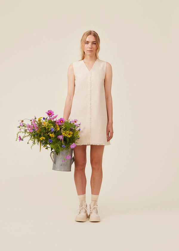 Short sleeveless dress in linen and cotton. IngridMD dress has a v-neckline and raw edges in front and at the bottom.