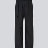 Black pants in recycled nylon. AmayaMD pants have a high waist and straight legs with adjustable drawstring at hem. Covered elasticated waist and two large pockets on the legs.