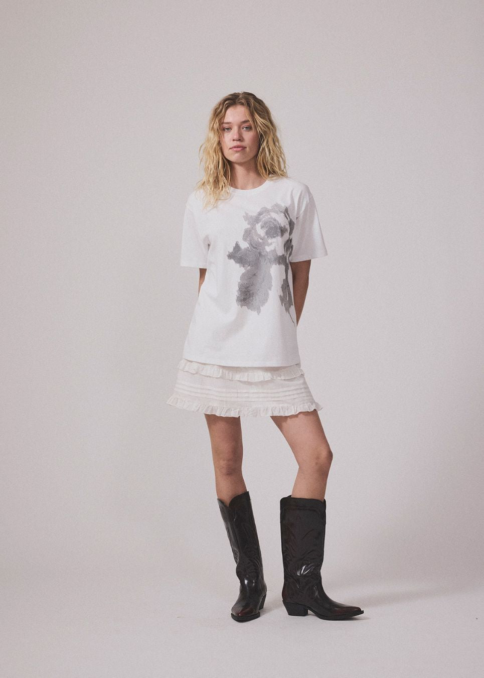 Short white skirt in 100% organic cotton. NillaMD short skirt has a loose skirt with pleats and frill details, and an elastic waist with a smock.

