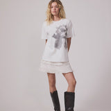Short white skirt in 100% organic cotton. NillaMD short skirt has a loose skirt with pleats and frill details, and an elastic waist with a smock.
