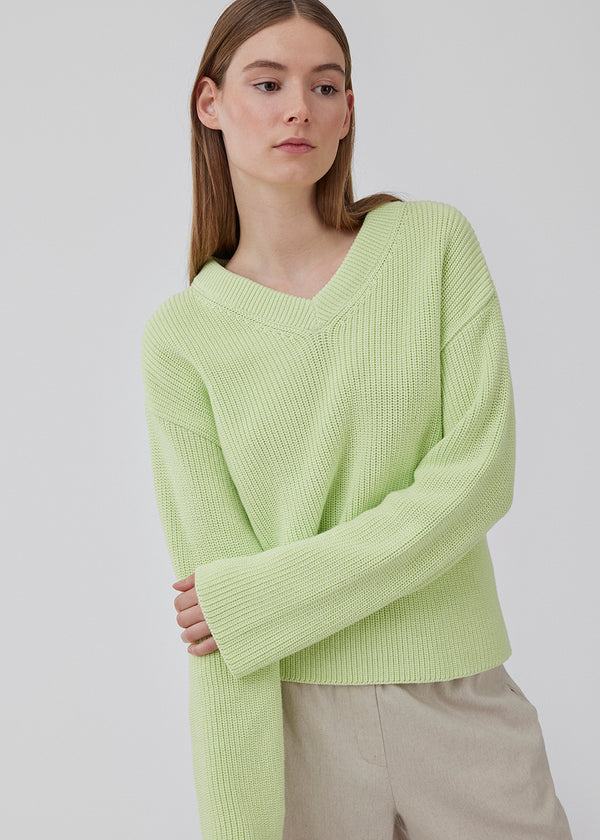 GalenMD v-neck in bright green is knitted from organic cotton with an oversized fit, long wide sleeves, a v-neck, and dropped shoulders. The model is 175 cm and wears a size S/36.<br>