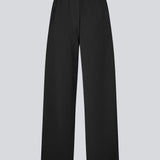 Loose black trousers with wide legs and a relaxed fit. Featuring an elastic waistband with drawstring for a comfortable, adjustable waist. White side stripes add a sporty and modern touch to the otherwise classic design. Perfect for casual everyday wear or more elevated styling – easy to pair with everything from t-shirts to dressy tops.