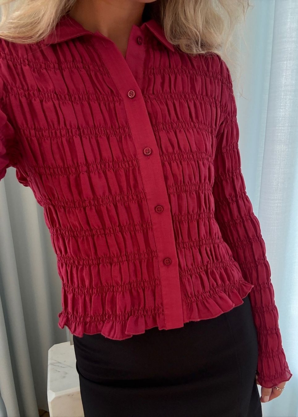 Fitted long-sleeved top in smock. Posiemd shirt has a button closure and a shirt collar. The model is 175 cm and wears a size s/36.
