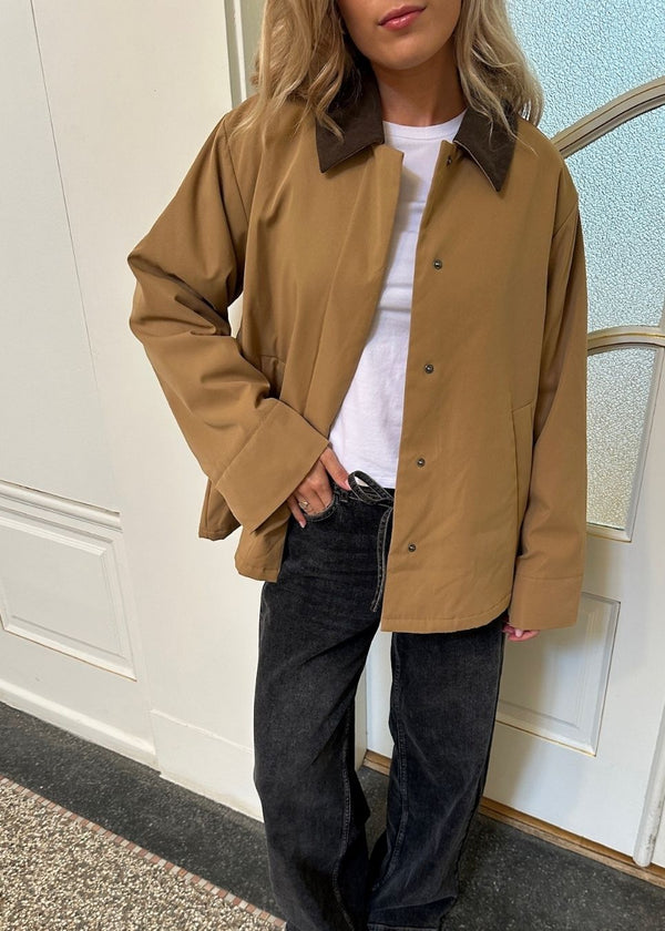 Lose jacket in beige with a contrast corduroy collar and hidden press buttons. Orkidemd jacket has an inverted pleat on the back.