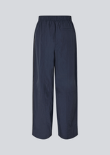 Dark blue tracksuitpants in 100% recycled nylon. Volmermd pants has piping along the sideseam and cutline details for a sporty look.