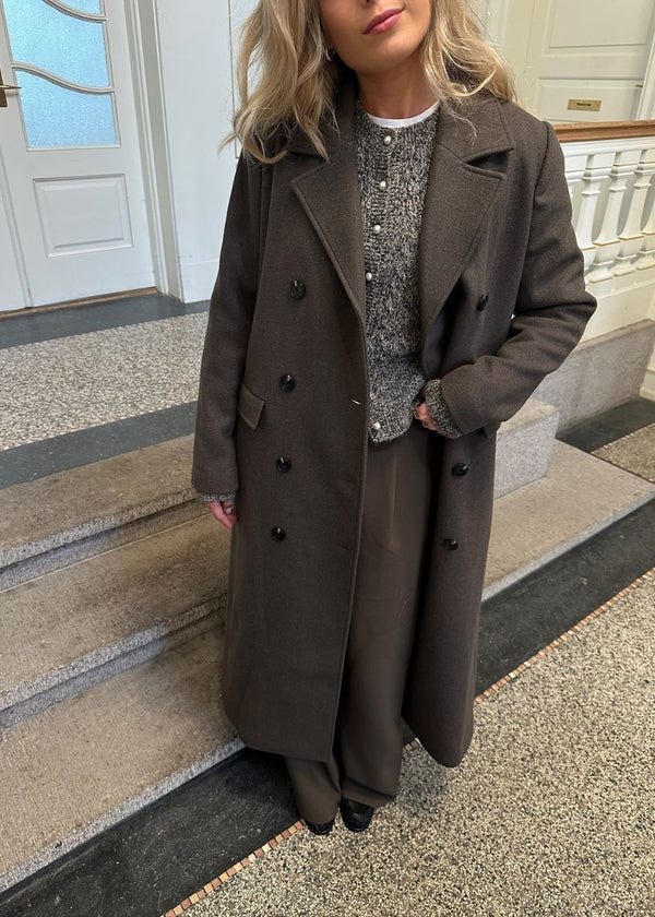 Classic, double-breasted wool coat with collar and notch lapels. JuniperMD coat has a relaxed fit, lining and a slit in the back.