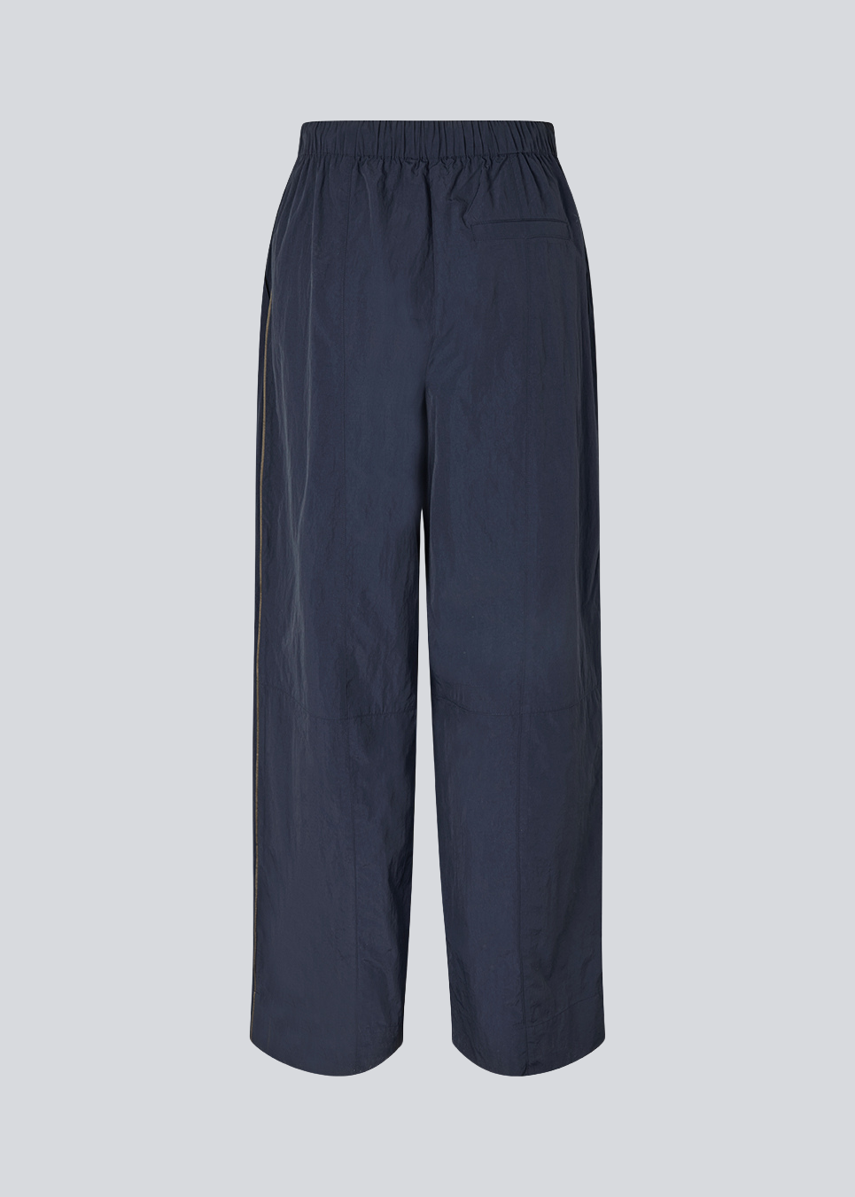 Dark blue tracksuitpants in 100% recycled nylon. Volmermd pants has piping along the sideseam and cutline details for a sporty look.