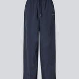 Dark blue tracksuitpants in 100% recycled nylon. Volmermd pants has piping along the sideseam and cutline details for a sporty look.
