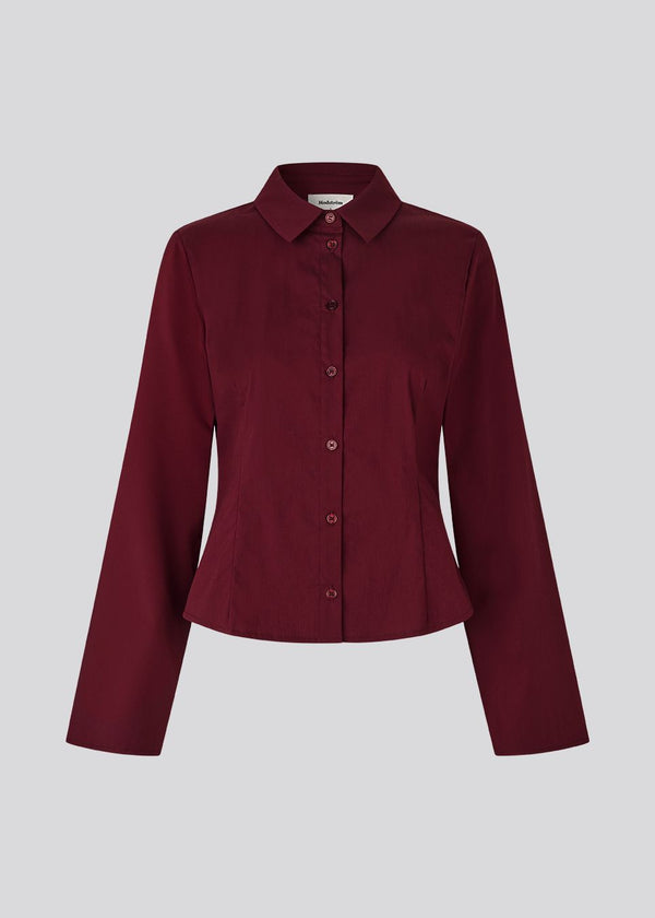 Classic fitted shirt in a cotton mix in a beautiful dark red color/burgundy. ToveMD shirt has a collar, button closure in front and long wide sleeves. The color matches the shirt in the model picture.
