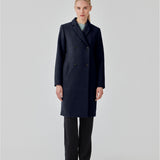 Beautiful, knee-length wool coat in navy sky. Odelia coat is closed at front by 4 buttons and is fitted around the waist, which gives a feminine look. Because of the high content of wool the jacket will be perfect for fall and the mild winters.
