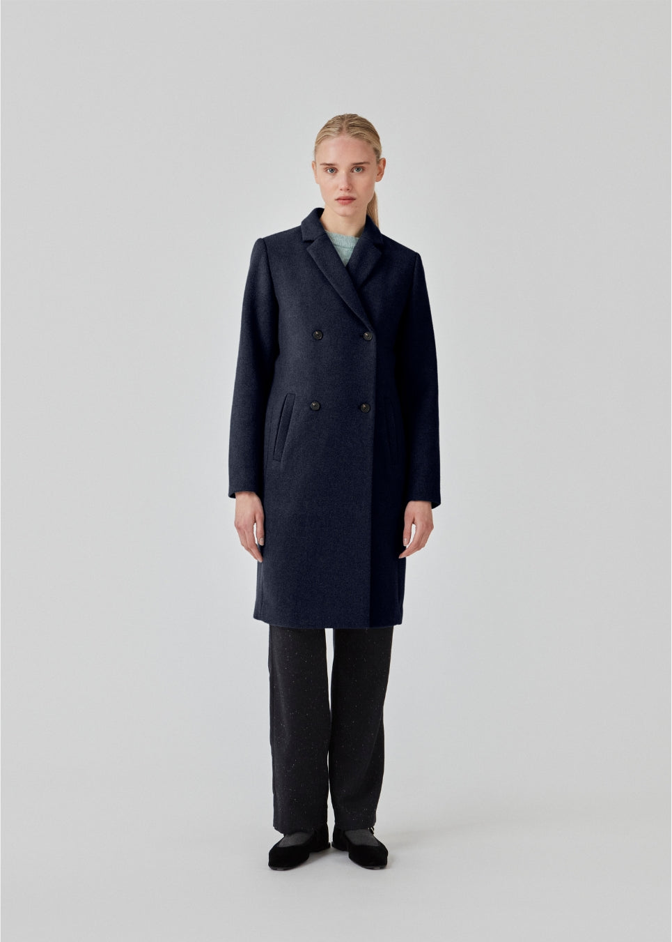 Beautiful, knee-length wool coat in navy sky. Odelia coat is closed at front by 4 buttons and is fitted around the waist, which gives a feminine look. Because of the high content of wool the jacket will be perfect for fall and the mild winters.