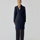 Beautiful, knee-length wool coat in navy sky. Odelia coat is closed at front by 4 buttons and is fitted around the waist, which gives a feminine look. Because of the high content of wool the jacket will be perfect for fall and the mild winters.