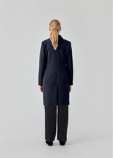 Beautiful, knee-length wool coat in navy sky. Odelia coat is closed at front by 4 buttons and is fitted around the waist, which gives a feminine look. Because of the high content of wool the jacket will be perfect for fall and the mild winters.