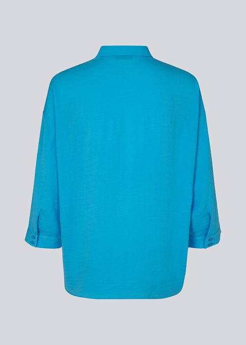 Beautiful blue shirt in a classic design. Alexis shirt has a collar and is closed at front by buttons. The shirt has 3/4 length sleeves and a chest pocket, which adds details. The model is 174 cm and wears a size S/36