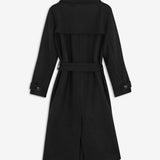 Black long double-breasted coat in a wool blend. It has notch lapels, shoulder tabs, wide cuff straps and a storm flap. A tie belt defines the waist, and a single vent opens at the back. Wear it belted over tailoring or open over a soft knit. The model is 175 cm and wears a size S/36.