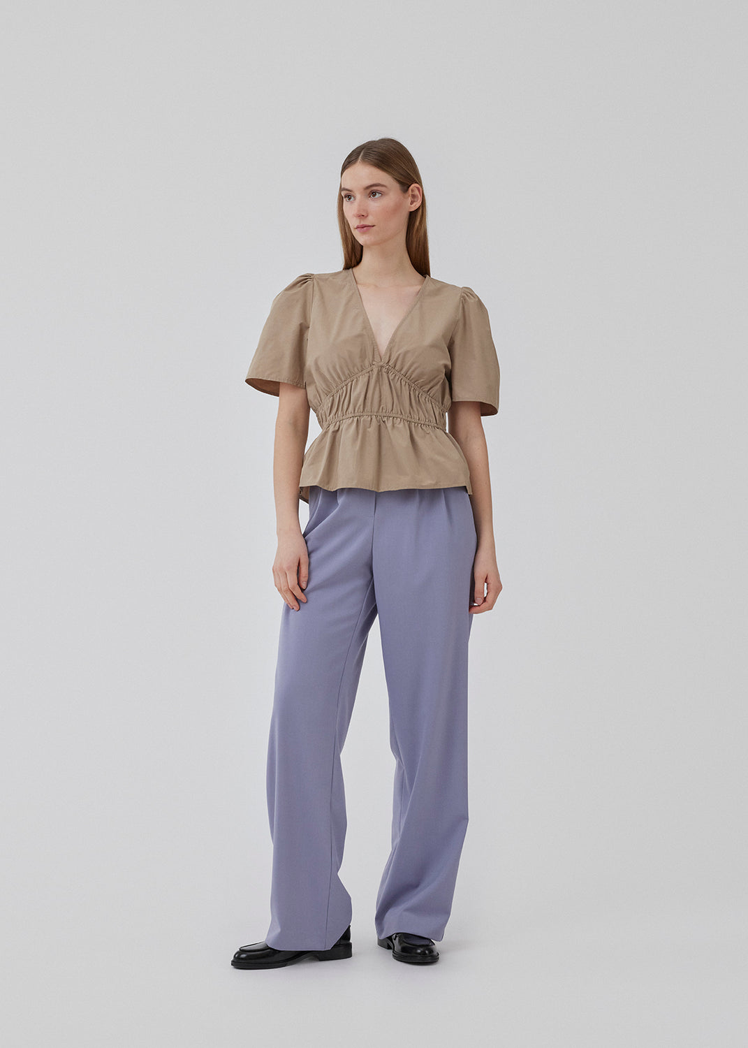 Beige top made from a cotton mix with short, slightly puffed, sleeves, and a deep v-neckline. DeenMD top has a flattering ruched detail below the chest and at the waist. The model is 177 cm and wears a size S/36.