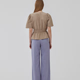 Beige top made from a cotton mix with short, slightly puffed, sleeves, and a deep v-neckline. DeenMD top has a flattering ruched detail below the chest and at the waist. The model is 177 cm and wears a size S/36.
