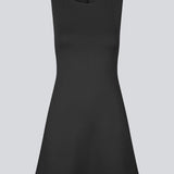 Fitted black mini dress in an A-line shape with a round neck and no sleeves. JosefineMD tank flare dress is made from a stretchy material. The model is 177 cm and wears a size S/36.