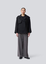 Cropped double-breasted wool coat with hidden buttons. EsmundMD jacket has classic coat details with raglan sleeves and an high yoke at the back. Lined. The model is 175 cm and wears a size S/36.