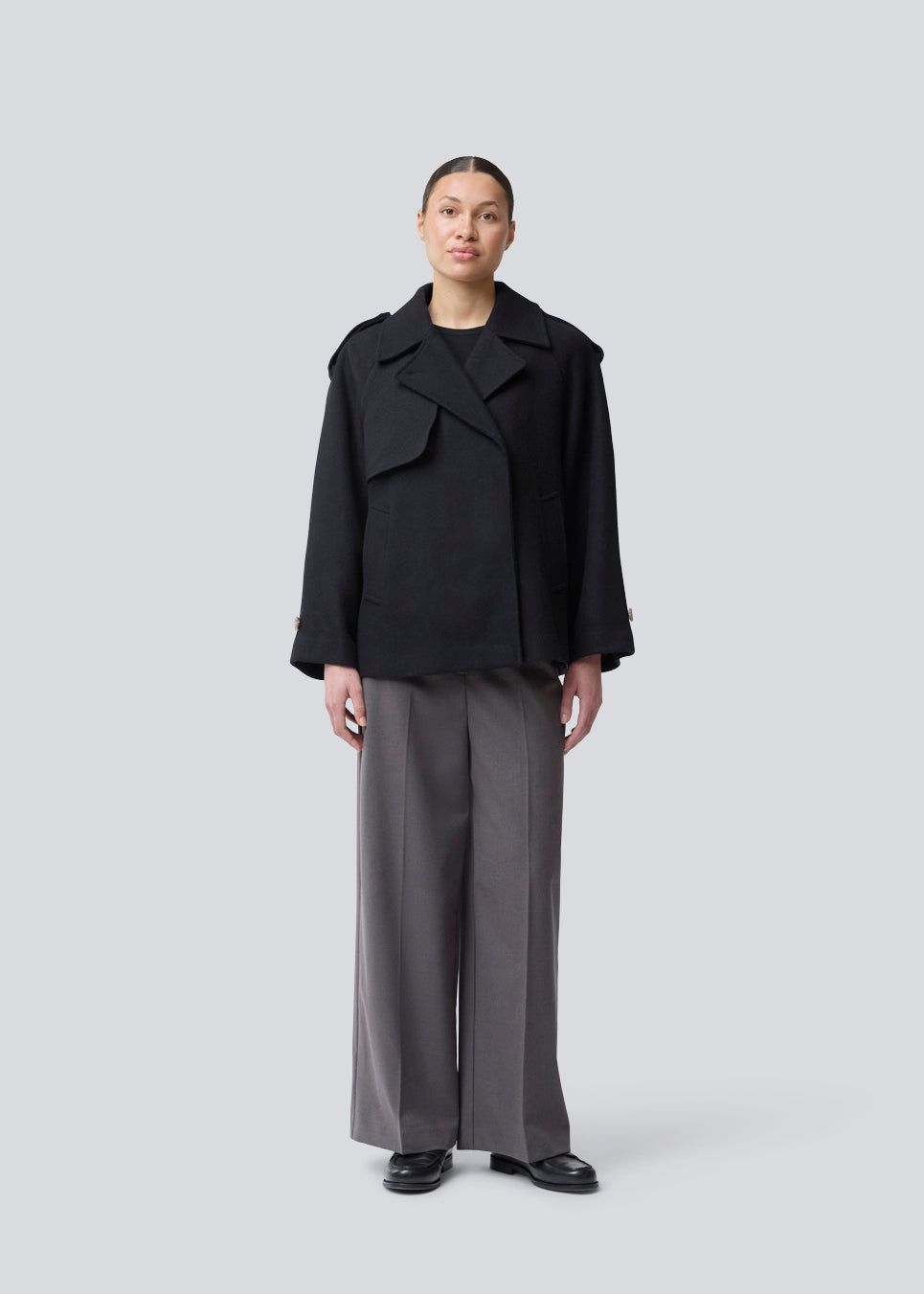 Cropped double-breasted wool coat with hidden buttons. EsmundMD jacket has classic coat details with raglan sleeves and an high yoke at the back. Lined. The model is 175 cm and wears a size S/36.