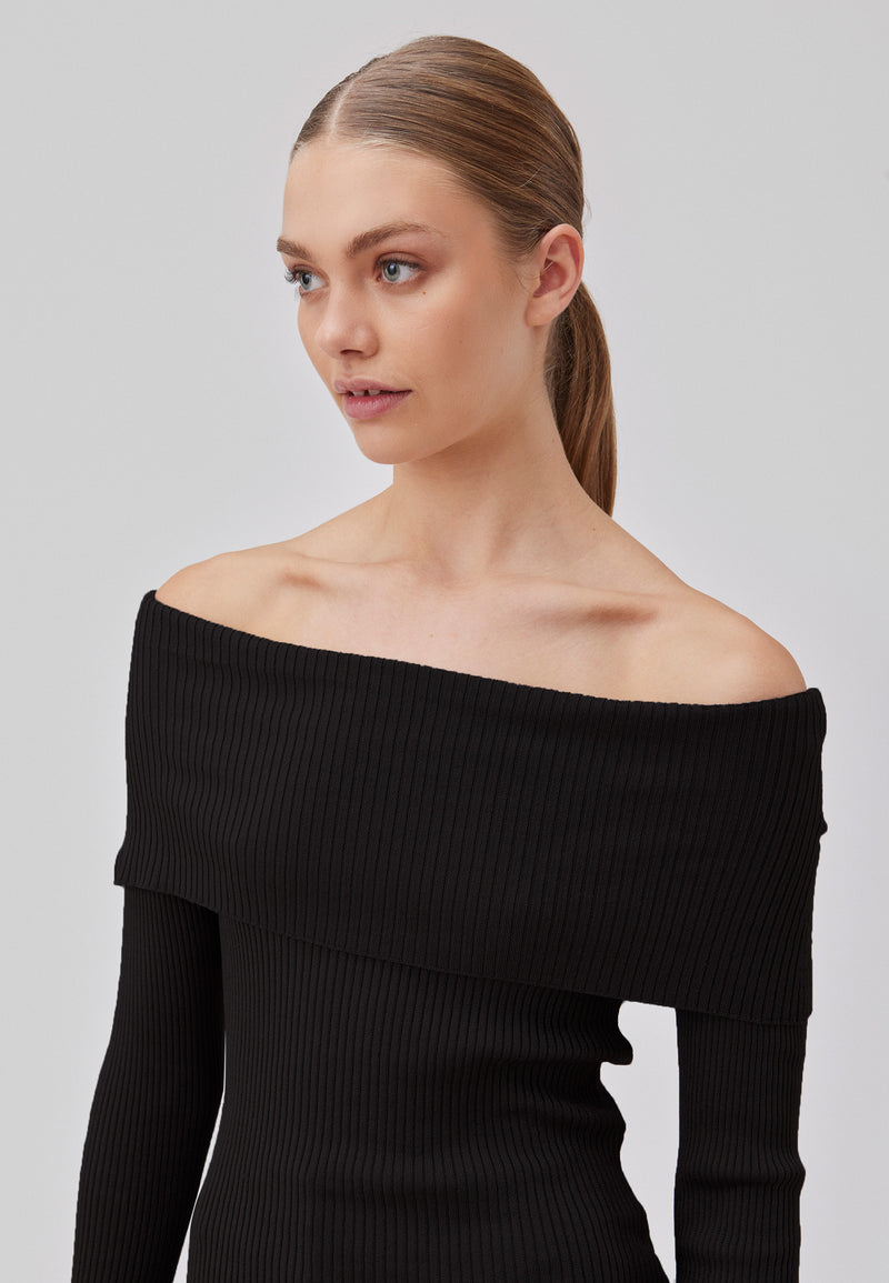 Ribknitted black top in a stretchy quality. GaryMD top has a tight fit with long sleeves and an off shoulder neckline with folded detail. The model is 175 cm and wears a size S/36.