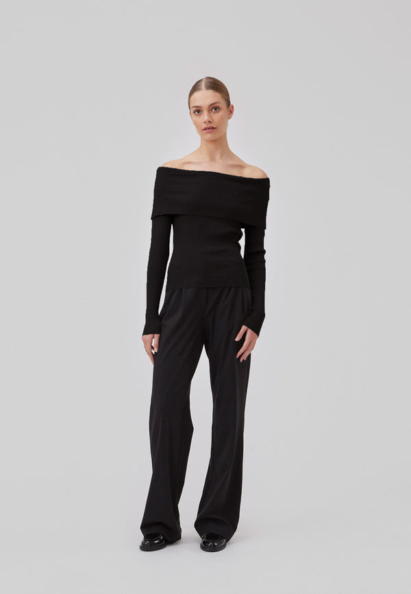 Ribknitted black top in a stretchy quality. GaryMD top has a tight fit with long sleeves and an off shoulder neckline with folded detail. The model is 175 cm and wears a size S/36.