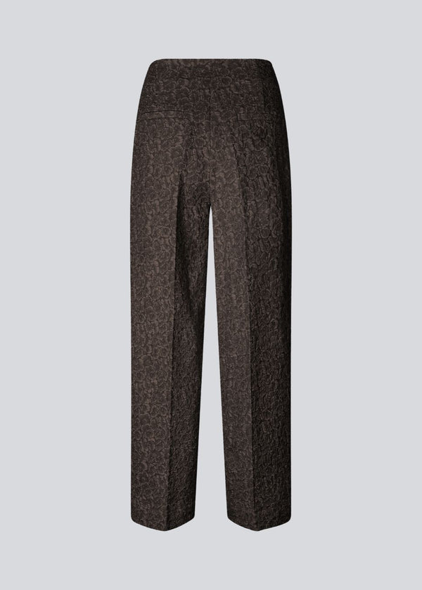 Brown pants with straight legs in a structured material. HollisMD pants have a medium waist with hidden zipper at one side, and two welt pockets on the back.&nbsp;