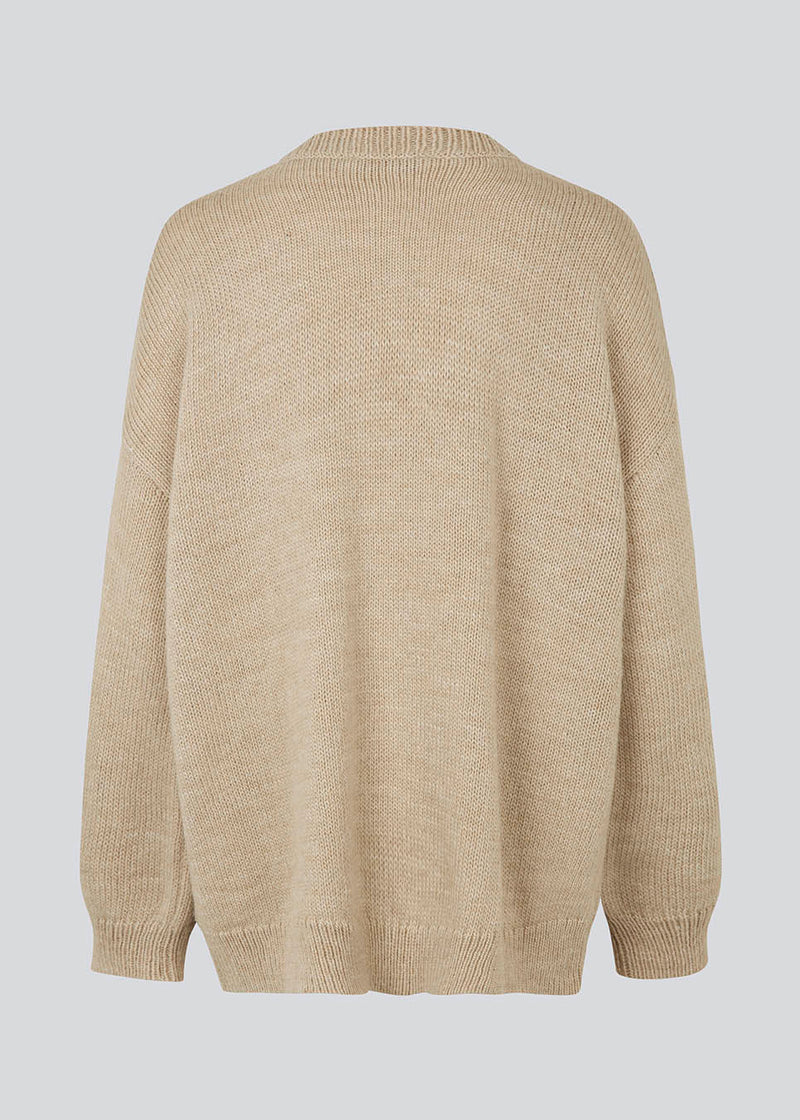 Oversized knitted jumper in beige woven from a wool and alpaca blend. TalaMD o-neck has a round neck, dropped shoulders and a longer back. Ribknitted trims on neck, sleeves and hem. 