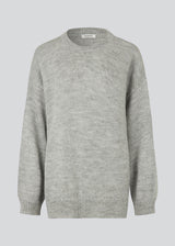 Oversized knitted jumper in grey melange in woven from a wool and alpaca blend. TalaMD o-neck has a round neck, dropped shoulders and a longer back. Ribknitted trims on neck, sleeves and hem. 