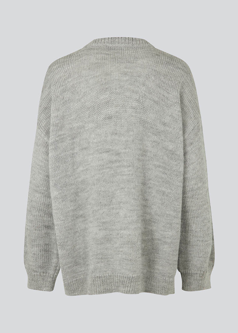 Oversized knitted jumper in grey melange in woven from a wool and alpaca blend. TalaMD o-neck has a round neck, dropped shoulders and a longer back. Ribknitted trims on neck, sleeves and hem. 