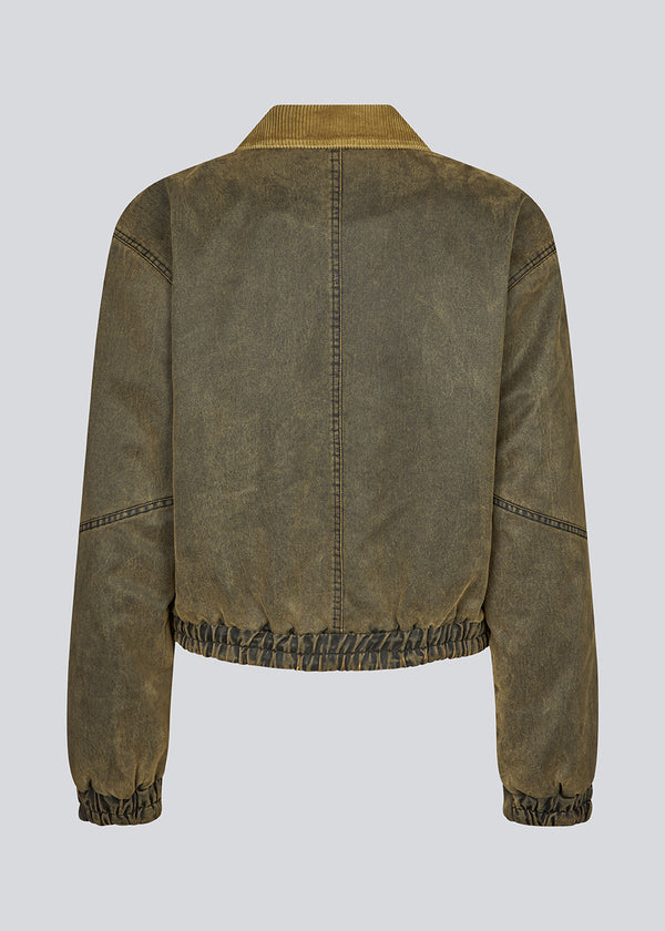 Classic bomber jacket in fake oilskin. JanMD jacket has padding, a hidden zipper and button closure at the sleeves and in front.