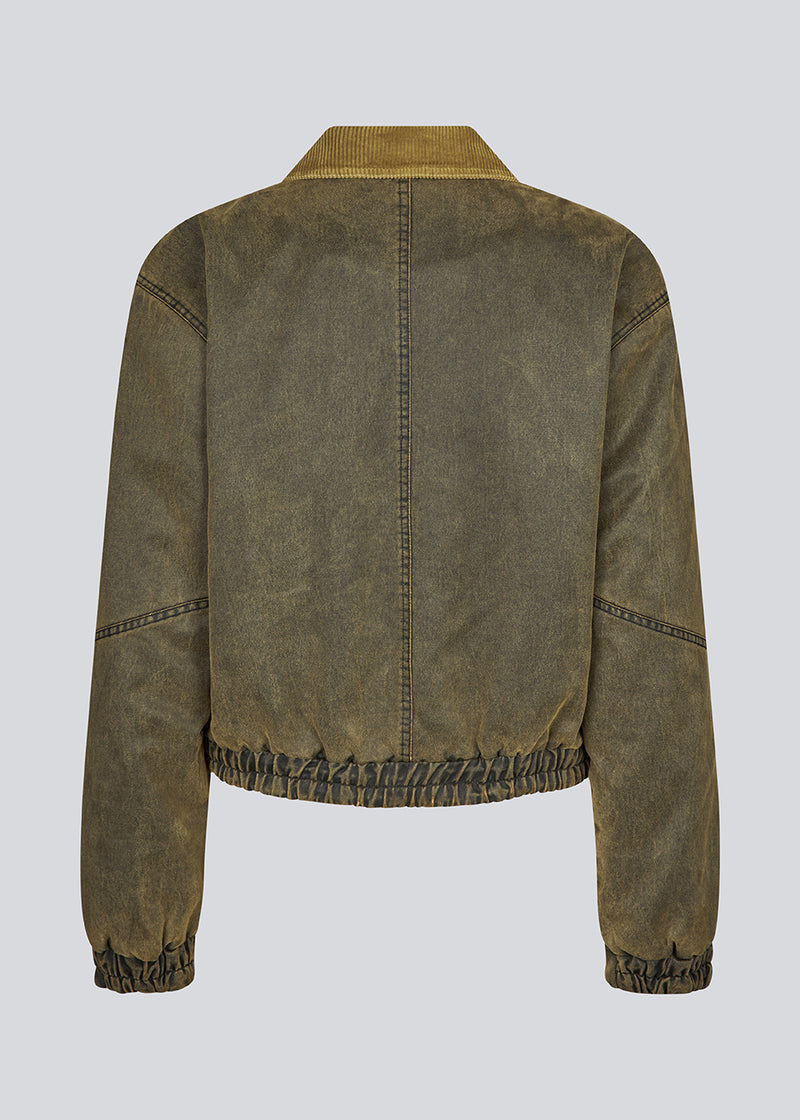 Classic bomber jacket in fake oilskin. JanMD jacket has padding, a hidden zipper and button closure at the sleeves and in front.