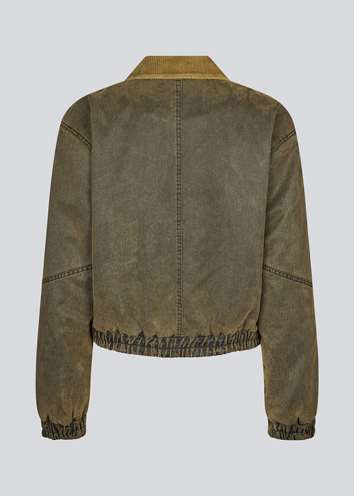 Classic bomber jacket in fake oilskin. JanMD jacket has padding, a hidden zipper and button closure at the sleeves and in front.